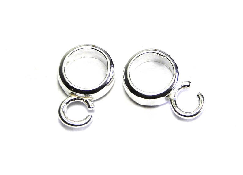 Puede incluir: Dos anillos de salto plateados con un bucle soldado en cada uno. Los anillos de salto son redondos y tienen un acabado liso.