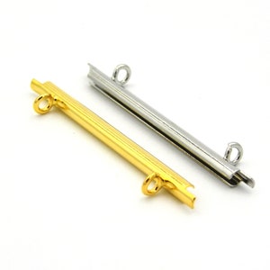 May include: Two metal connector bars for jewelry making. One is gold and the other is silver.