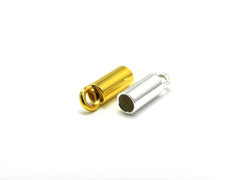 May include: Two metal end caps for jewelry making. One is gold and the other is silver.
