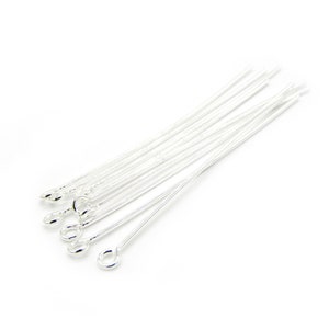 May include: A selection of silver eye pins, suitable for jewellery making. Each pin features a loop at one end and a straight wire. The eye pins are displayed against a white backdrop.
