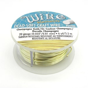 Puede incluir: Una bobina de alambre artesanal redondo, suave y antideslustre de calibre 20, de color oro champán, que mide 6 yardas (5,5 metros). La etiqueta dice "Wire elements DEAD-SOFT CRAFT WIRE ROUND Champagne Gold/Or Couleur Champagne/Dorado Champagne 20 gauge (0.032"/0.81 mm) 6 yd/5.5 m TARNISH-RESISTANT/RÉSISTANT AU TERNISSEMENT/RESISTENTE AL DESLUSTRE"