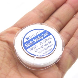 May include: A white spool of elastic beading cord labeled "MIYUKI Elastic Beading Cord H639E 20m(22yds) 03~0.5mm dia 100% Polyurethane Made in Japan"