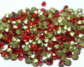 May include: A pile of red and gold rhinestones, perfect for crafting and jewelry making.