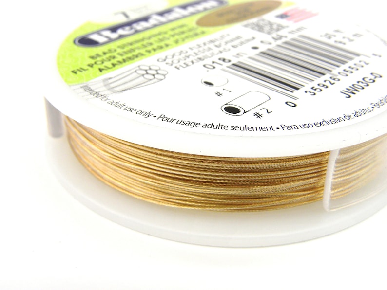 May include: A spool of gold-colored beading wire. The label reads "Beadalon", "Beading Wire", "Fil Pour Bijoux", "Alambre Para Bisuteria", "Souple et Flexible", "018 in", "12 m", "Intended for adult use only. Pour usage adulte seulement. Para uso exclusivo de adultos."