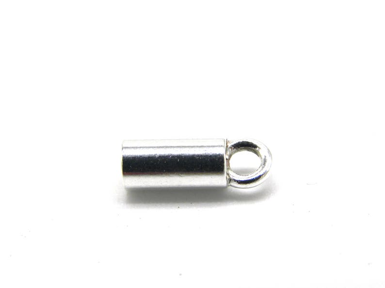 May include: Silver-toned metal end cap with a small loop. The end cap is cylindrical and has a smooth finish.