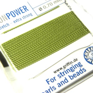 May include: Close-up of a spool of green nylon power cord, labeled "NYLONPOWER no stretch - extra strong" and "Ø 0,70 mm". The cord is designed for stringing pearls and beads. The Griffin logo is visible in the lower right corner.
