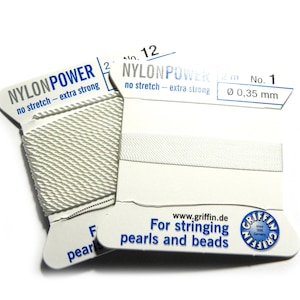 Op de afbeelding: Twee spoelen witte nylon power-koord, gelabeld "NYLONPOWER no stretch - extra strong" en "NYLONPOWER 12m No. 1 Ø 0,35 mm". De spoelen zijn gelabeld "Voor het rijgen van parels en kralen" en hebben het Griffin-logo.