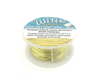 May include: A spool of 22 gauge, 0.025 inch, dead-soft craft wire in champagne gold color. The wire is tarnish-resistant and comes in a round spool with a label that reads "Wire Elements Dead-Soft Craft Wire Round Champagne Gold/Or Couleur Champagne/Dorado Champagne 22 gauge (0.025"/0.64 mm) - 8 yd/7.3 m Tarnish-Resistant/Resistant au ternissement/Resistente al deslustre".
