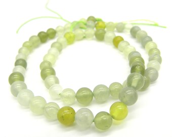 May include: A strand of green jade beads, some with a lighter shade and some with a darker shade of green. The beads are round and smooth, and they are strung on a thin cord.
