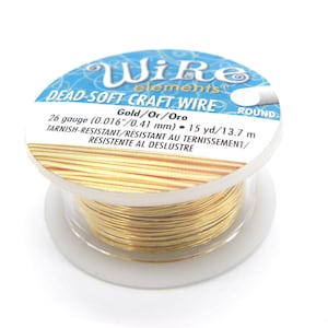 Op de afbeelding: Een spoel met 26 gauge goud draad voor knutselen, 13,7 meter lang, is anti-aanslag en zeer zacht. De spoel is gelabeld met "Wire elements DEAD-SOFT CRAFT WIRE Gold/Or/Oro ROUND 26 gauge (0.016"/0.41 mm) 15 yd/13.7 m TARNISH-RESISTANT/RESISTANT AU TERNISSEMENT/ RESISTENTE AL DESLUSTRE".