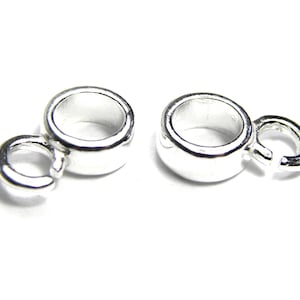 Puede incluir: Dos tapas de cuentas de metal plateadas con un bucle en un lado y un anillo de salto en el otro. Las tapas de cuentas est&aacute;n dise&ntilde;adas para ser utilizadas en la elaboraci&oacute;n de joyas.