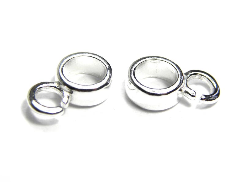 Puede incluir: Dos tapas de cuentas de metal plateadas con un bucle en un lado y un anillo de salto en el otro. Las tapas de cuentas est&aacute;n dise&ntilde;adas para ser utilizadas en la elaboraci&oacute;n de joyas.