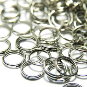 Può includere: Un mucchio di anelli di salto argentati, un tipo di anello di metallo utilizzato per la creazione di gioielli e l'artigianato.