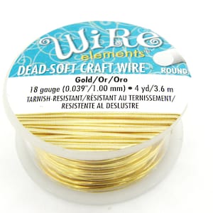 Puede incluir: Una bobina de alambre artesanal de oro de calibre 18, etiquetada como "Dead-Soft Craft Wire" y "Gold/Or/Oro". El alambre es resistente al deslustre y mide 4 yardas o 3,6 metros.