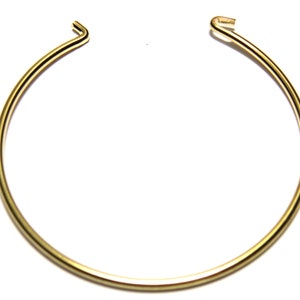 Könnte beinhalten: Ein Set aus drei Keramikbechern mit gesprenkelter, cremefarbener Glasur. Jeder Becher zeigt ein handgemaltes Blumendesign in Blau-, Grün- und Gelbtönen. Die Becher haben eine einfache, abgerundete Form.