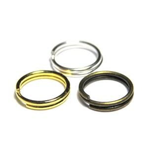 Op de afbeelding: Drie sleutelringen in verschillende afwerkingen: goud, zilver en brons. Elke ring is dubbel gelust.