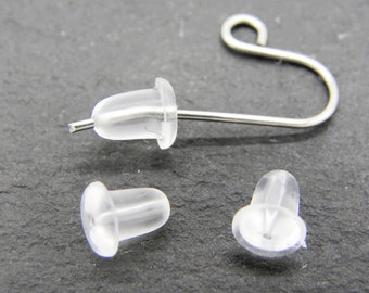 May include: Three clear plastic earring backs, two are flat and one is attached to a silver earring hook.