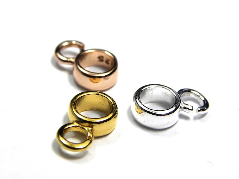 Puede incluir: Tres anillos de salto de metal en oro, plata y oro rosa. Cada anillo tiene un peque&ntilde;o bucle en un lado.