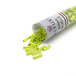 Könnte beinhalten: Eine kleine, durchsichtige Tube gefüllt mit limegrünen Glas-Bugle-Perlen. Die Tube trägt ein Etikett mit der Aufschrift "6mm Bugle Miyuki".
