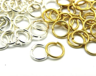 May include: A pile of silver and gold jump rings. The jump rings are small and round, and they are perfect for jewelry making.