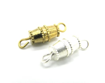 May include: Two metal clasps for jewelry making. One is gold and the other is silver. Both have a decorative design and a hook.