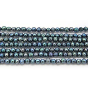 May include: A strand of small, round, dark peacock-coloured pearls arranged in five horizontal rows. Each pearl features a smooth, lustrous surface with iridescent blue, green, and purple undertones, reflecting light across the entire collection.