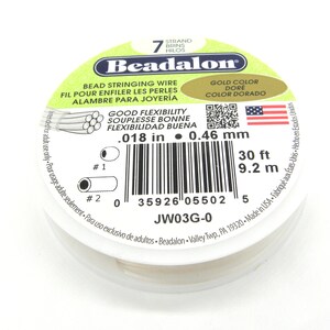 May include: A spool of 7-strand Beadalon bead stringing wire in gold color. The wire is 30 feet long and 0.018 inches in diameter. The label also states that the wire has good flexibility and is made in the USA.