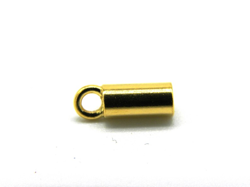 May include: Gold-toned metal end cap with a small loop. The end cap is cylindrical in shape.