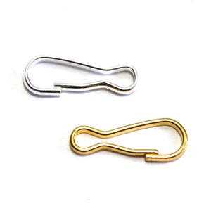 May include: Two metal key rings, one silver and one gold. Both are in the shape of a loop with a small opening at the top.