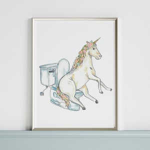 Può includere: Un'illustrazione ad acquerello di un unicorno con una corona di fiori seduto su un water. L'unicorno è bianco con una corona di fiori rosa e blu. Il water è bianco e blu.