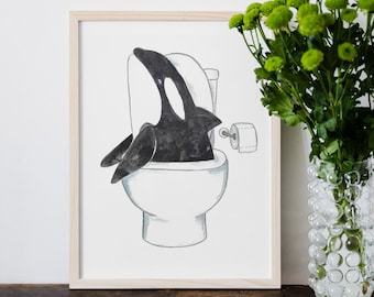 May include: A framed illustration of a black and white orca whale sitting on a white toilet with a roll of toilet paper hanging off the side.