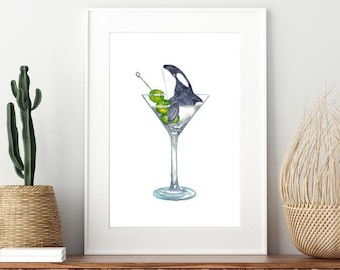 May include: A watercolor painting of a black and white orca swimming in a martini glass with green olives. The orca is facing the left side of the image. The martini glass is on a white background.