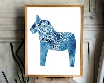 May include: A blue and white watercolor painting of a traditional Swedish Dala horse. The horse is standing on a white background and is framed in a natural wood frame.
