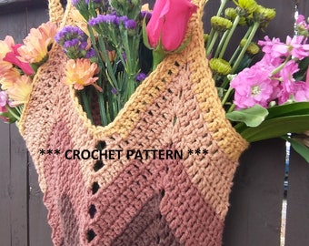 May include: A crocheted tote bag with a brown, orange, and white ombre pattern. The bag is hanging on a wooden fence and has a bouquet of flowers inside.
