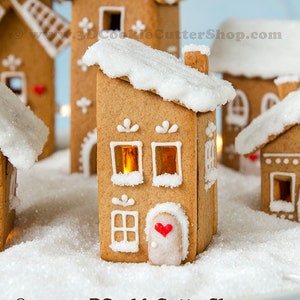 May include: Gingerbread houses with white icing accents and snowy roofs. The houses have windows with a warm glow, and some feature red heart decorations. The scene is set on a bed of white sugar, creating a festive holiday display.