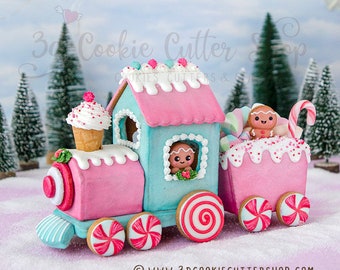 May include: A gingerbread house train with pink and blue icing, candy cane wheels, and a gingerbread person in the window. The train is decorated with sprinkles, candy, and a cupcake.