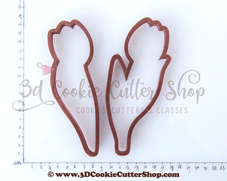 May include: Two brown plastic cookie cutters shaped like tulips. The cutters are approximately 8 cm tall and 3 cm wide.