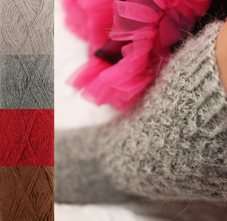 May include: A close-up of a gray knitted sock with a fuzzy texture. The sock is worn by a person wearing a pink tulle skirt.