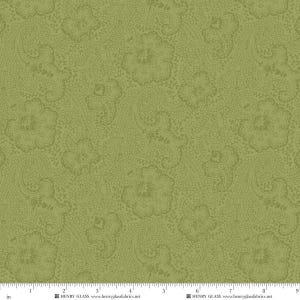 May include: A sage green fabric featuring a repeating lace-like floral and paisley pattern in a slightly darker shade of green. A white ruler at the bottom edge shows measurements in inches, with the text Henry Glass and henryglassfabrics.net.