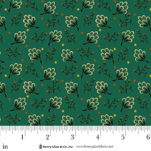 May include: Green fabric with a repeating pattern of cream-colored floral shapes, brown branches, orange dots, and yellow stars. The fabric has a ruler along the bottom edge, with measurements in inches. The text "Henry Glass & Co., Inc." is visible.