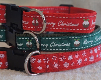 May include: Three dog collars with Christmas designs. The top collar is red with a white "Merry Christmas" message and a green and brown pudding design. The middle collar is green with a white "Merry Christmas" message and a green and brown pudding design. The bottom collar is red with a white snowflake design.