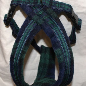 Pu&ograve; includere: Un'imbracatura per cani a quadri blu e verdi con fibbie in plastica nera e un anello di metallo. L'imbracatura &egrave; realizzata in un tessuto morbido e strutturato e presenta un classico motivo tartan. Il design &egrave; a tracolla.
