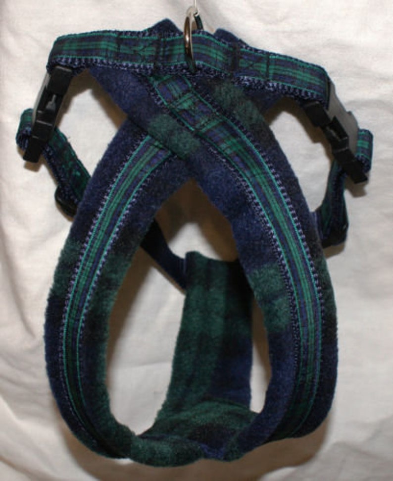 Pu&ograve; includere: Un'imbracatura per cani a quadri blu e verdi con fibbie in plastica nera e un anello di metallo. L'imbracatura &egrave; realizzata in un tessuto morbido e strutturato e presenta un classico motivo tartan. Il design &egrave; a tracolla.