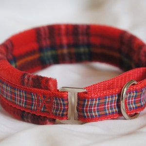 May include: Red and black tartan dog collar with a silver buckle and a ring for attaching a lead.