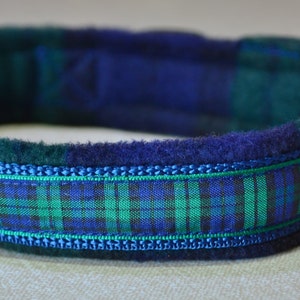 May include: A blue and green plaid dog collar with a fleece lining and a silver D-ring.