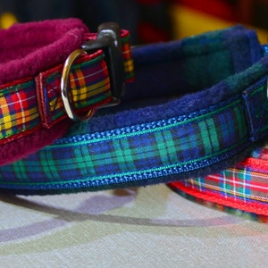 May include: Three dog collars with plaid patterns. The collars are red, blue, and burgundy with white and yellow accents. The collars are made of fleece and have a buckle closure.