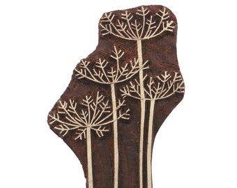 May include: A brown wooden block printing stamp with a design of three white stylized flower sprigs.