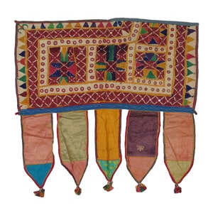 Puede incluir: Un tapiz de pared textil colorido, cosido a mano, con un patr&oacute;n geom&eacute;trico y acentos de espejo. Tiene cinco borlas largas y con flecos en tonos de rosa, verde, amarillo, morado y naranja.