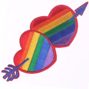 Könnte beinhalten: Zwei regenbogenfarbene Herzen mit einem Pfeil, der durch sie hindurchgeht. Die Herzen sind mit roten, orangen, gelben, grünen, blauen, indigoblauen und violetten Streifen bestickt. Der Pfeil ist blau.