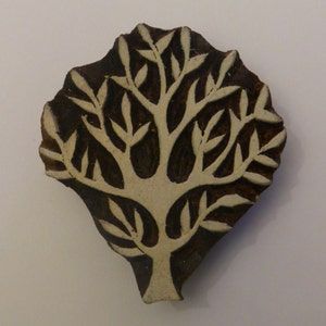 Peut inclure: Un bloc de bois sculpté représentant un arbre avec des branches et des feuilles blanches. La sculpture est un tampon d'impression traditionnel indien.